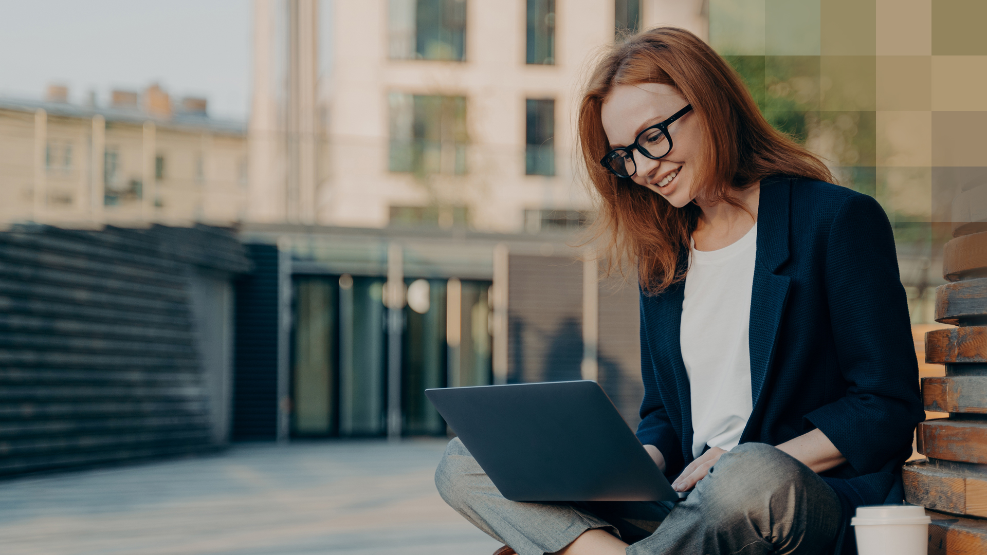 Une jeune femme avec des lunettes est assise dehors sur un banc avec un ordinateur portable et recherche des informations sur le modèle Telmed.
